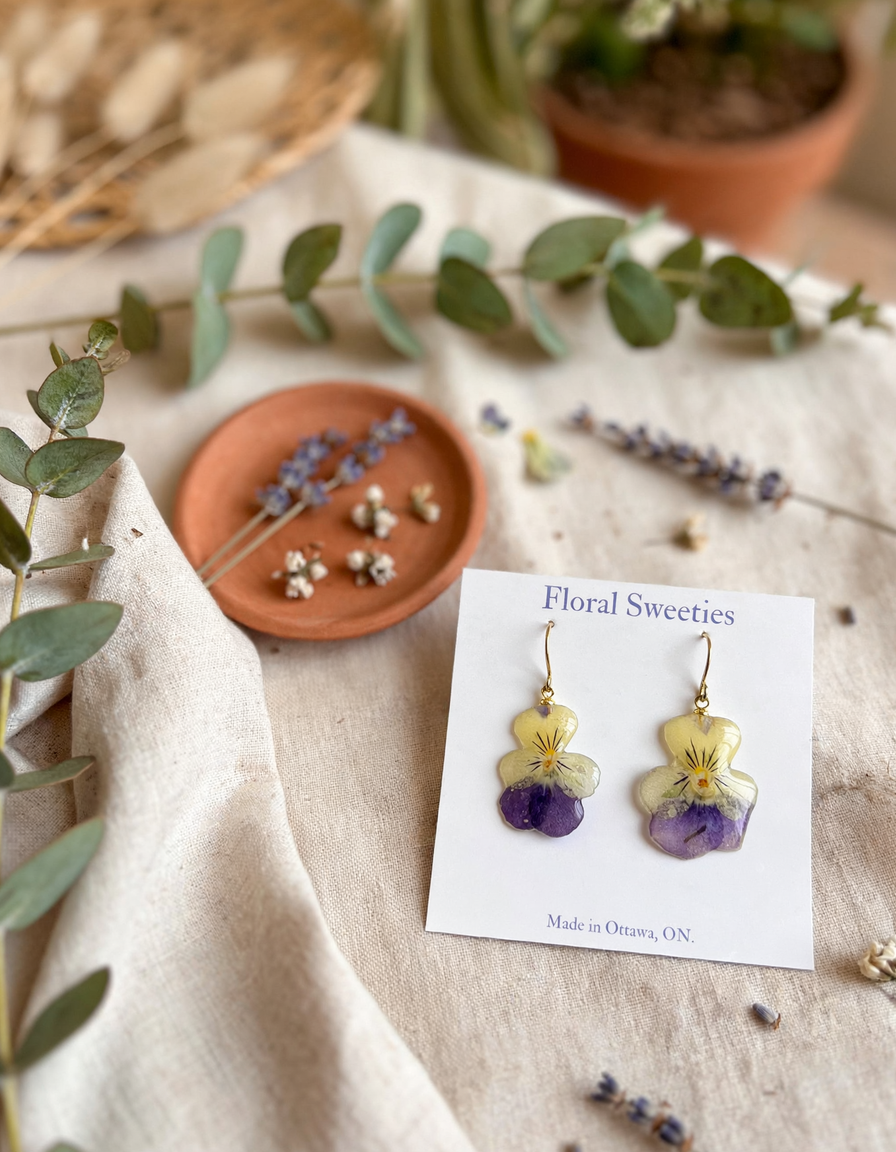 Pansy and violet resin earrings styled view showing yellow and purple petals