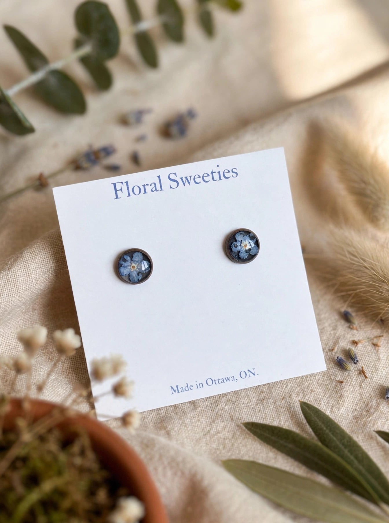Forget-me-not stud earrings close-up view showing the tiny blue flowers in resin